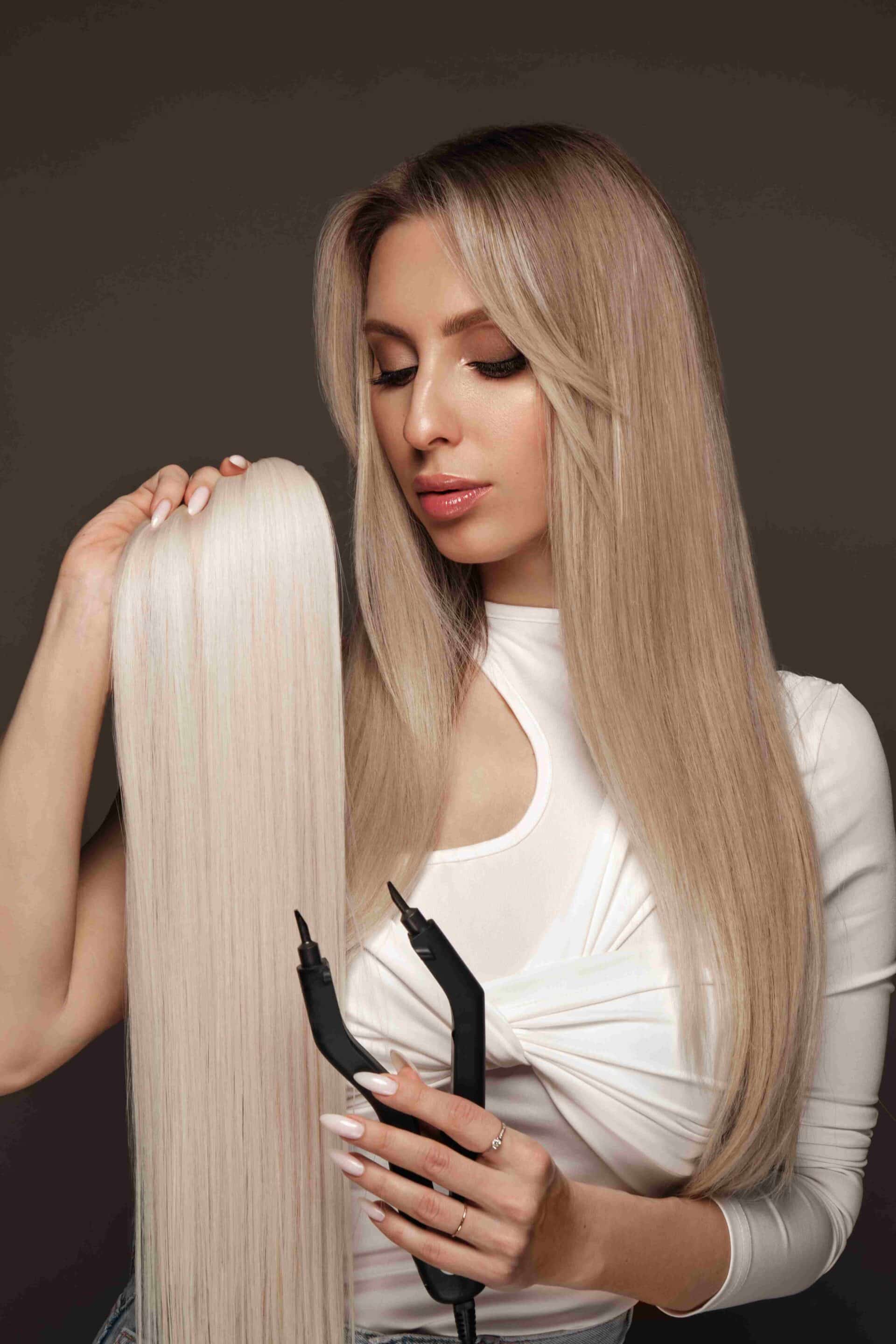 Professional stylist applying tape-in hair extensions at Biro Hair Studio in North York Toronto<br />
